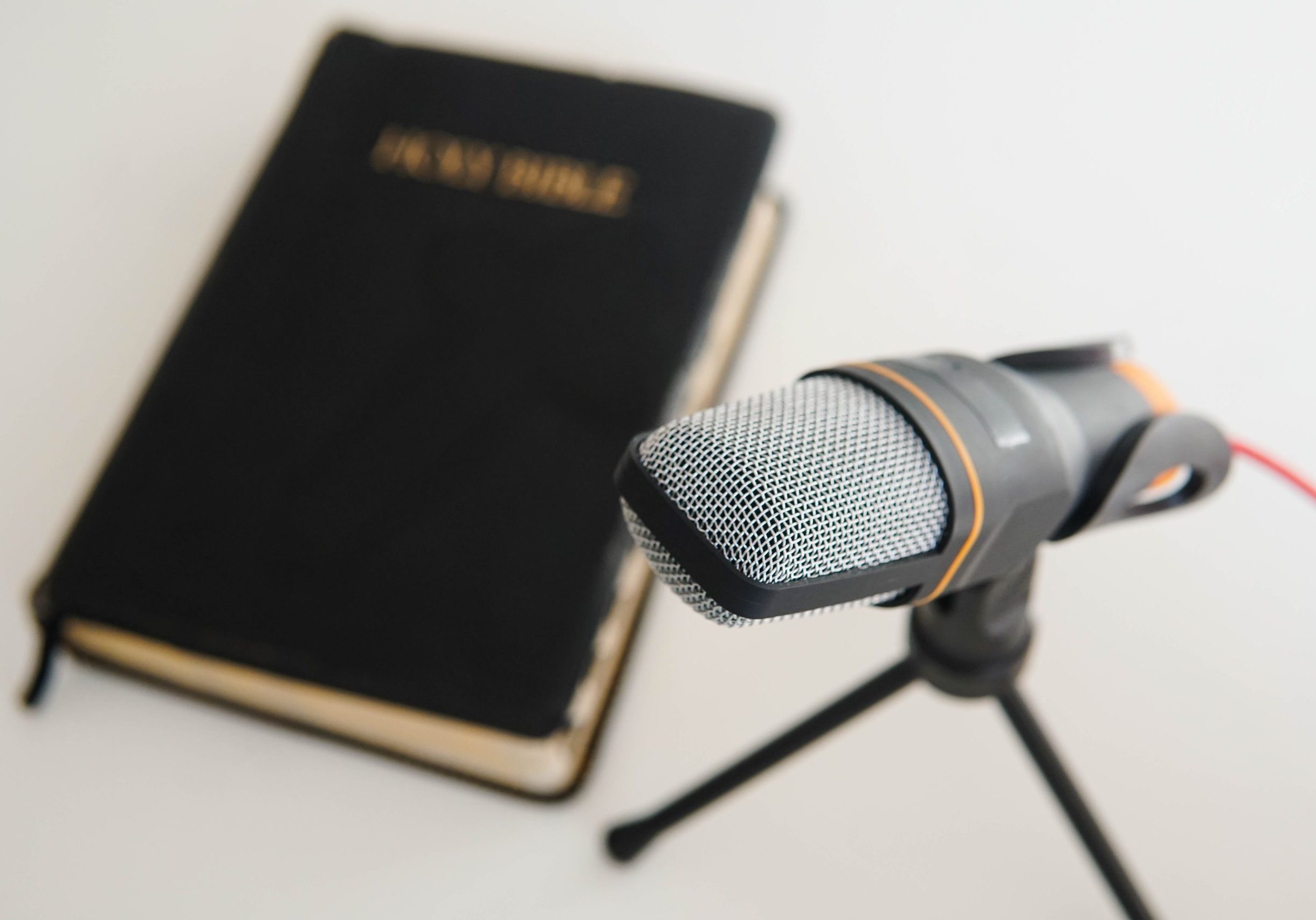 Bible Book With Microphone On Table. Christian Radio Broadcast. Bible book with microphone on table. Christian radio broadcast. Man records a online podcast.